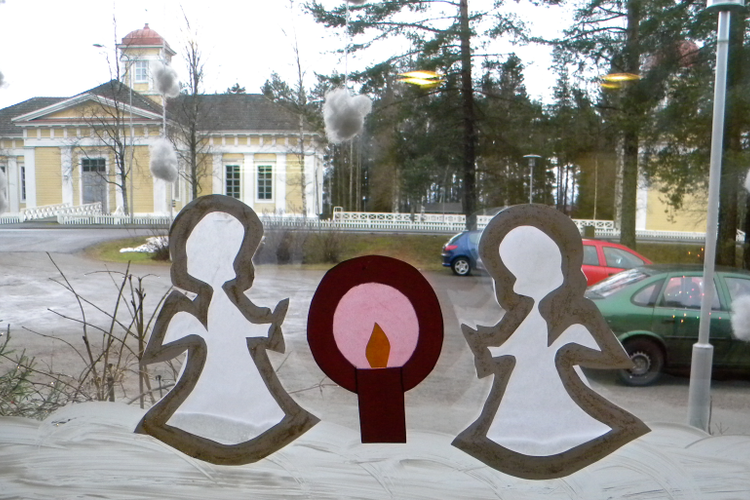 Kirkko ikkunasta, jossa paperienkeleitä kerhotilasta